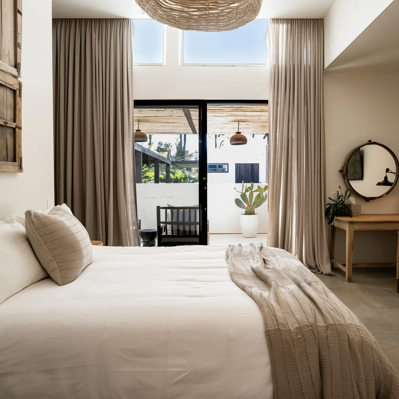 Neutral blockout curtains in a sunlit bedroom with timber accents — Byron Bay