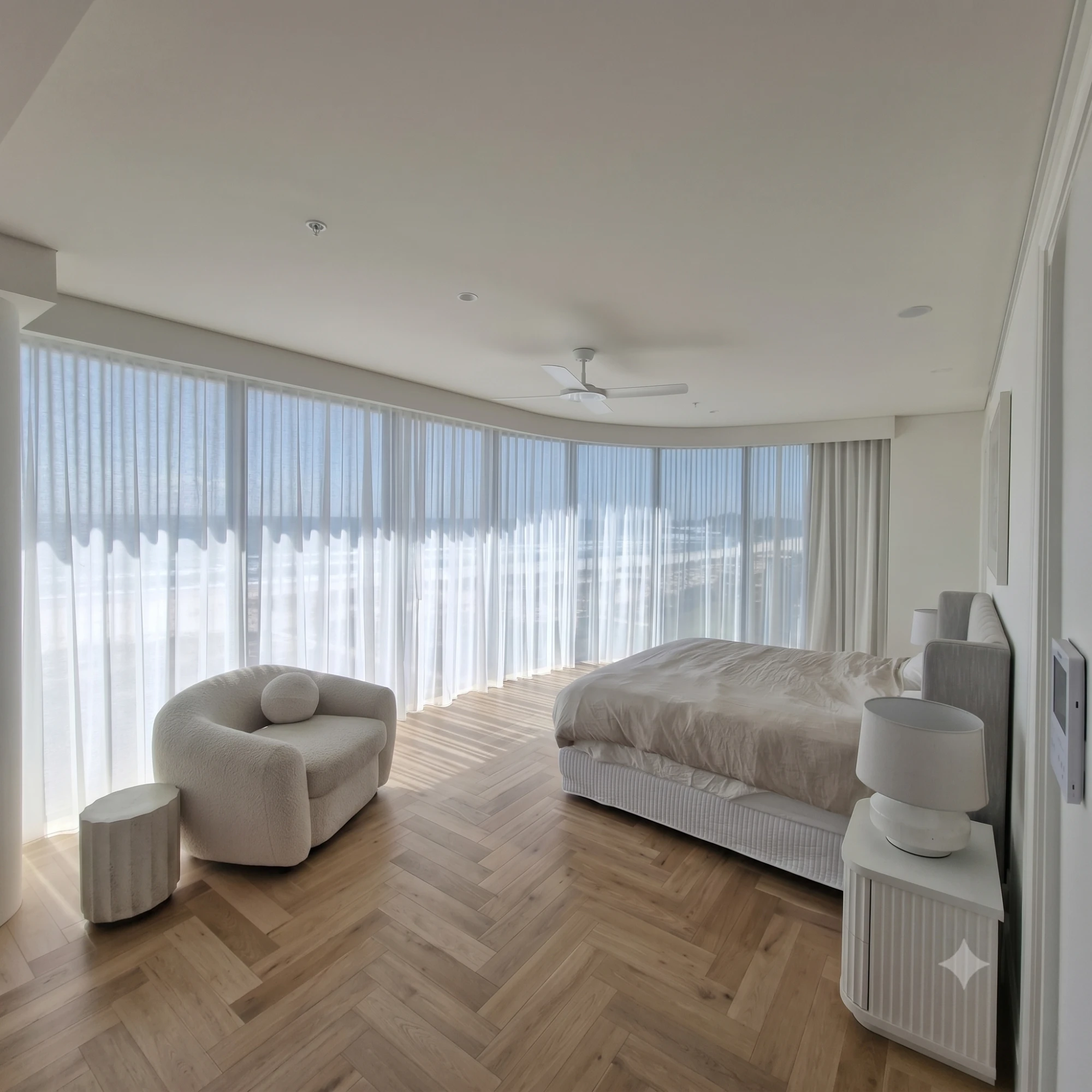 Curved floor-to-ceiling sheer curtains with ocean view in a luxury Gold Coast bedroom by Gold Coast Blinds and Shutters