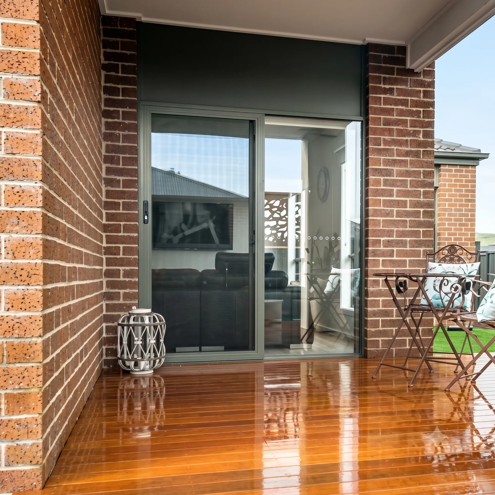 Long-lasting sliding security screen door on a brick patio with timber decking by Gold Coast Blinds and Shutters