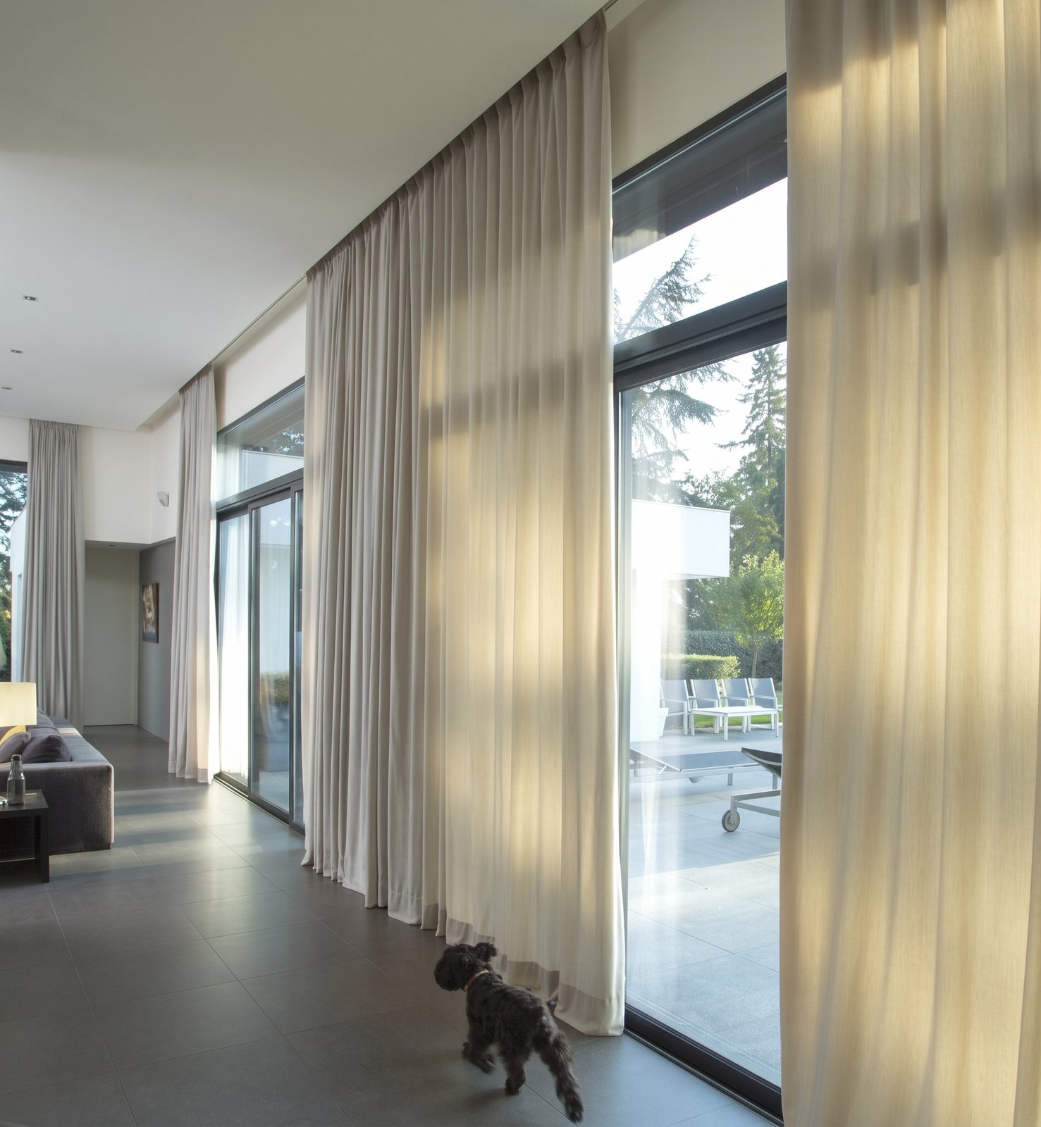 Floor-to-ceiling motorised sheer curtains across a living room, made by Gold Coast Blinds and Shutters